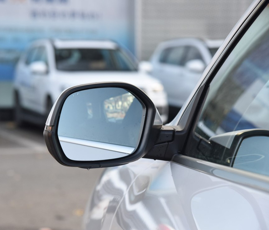 依次分布在车头两侧后视镜下方和车尾的四枚摄像头,形成全景泊车影像