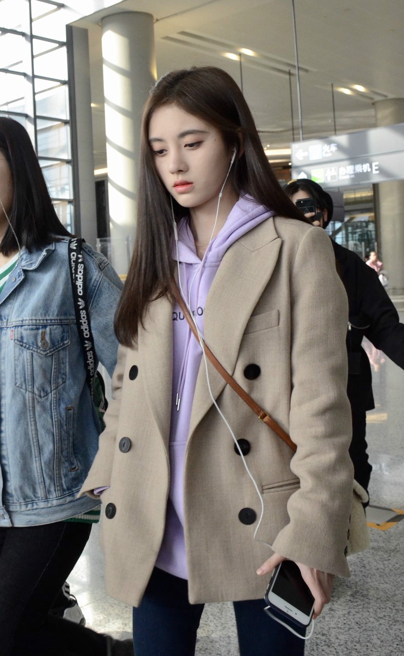 鞠婧祎穿卡其色西服内搭紫色连帽卫衣现身机场皮肤白皙