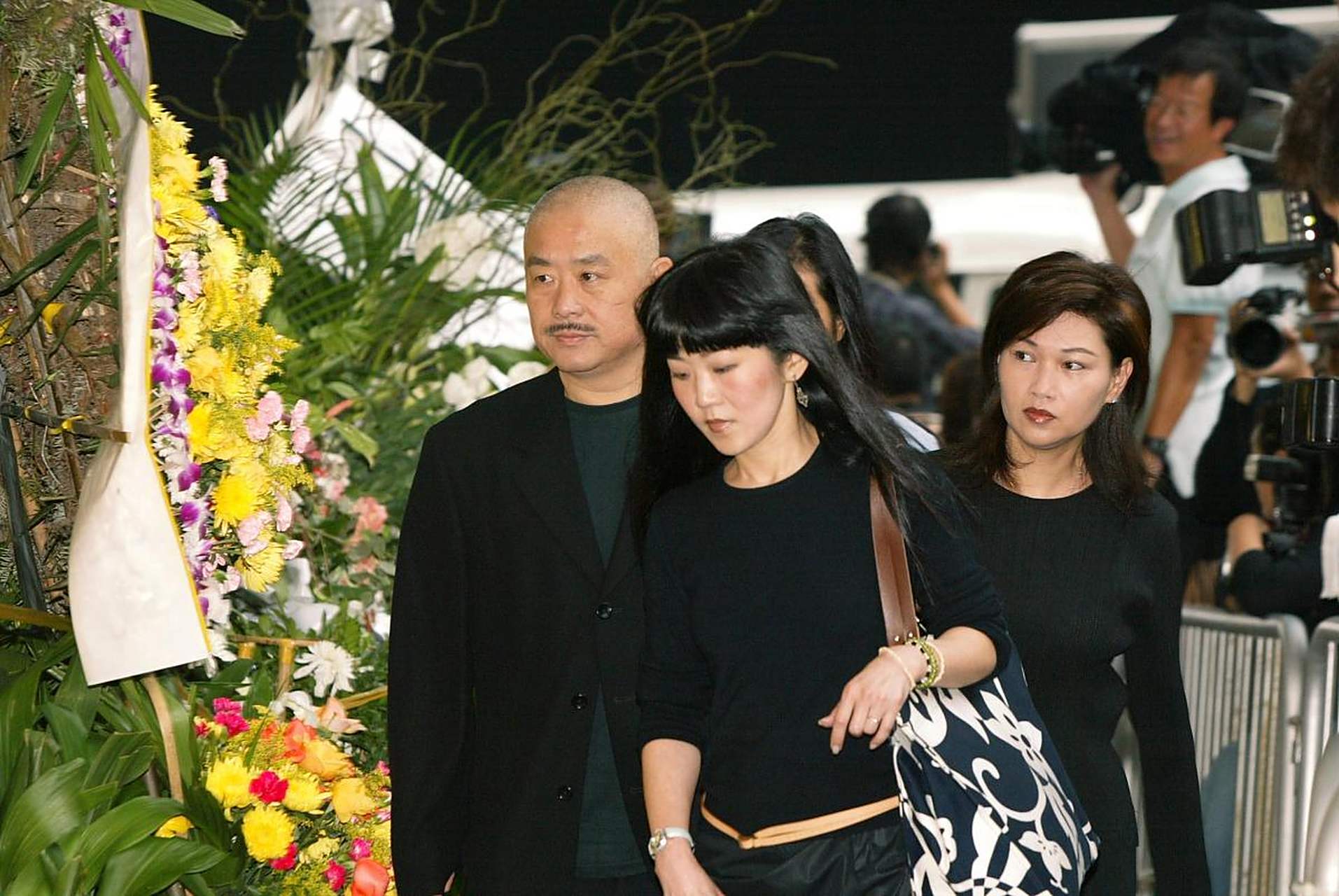 2003年,梅艳芳去世,葬礼上,她80岁的母亲覃美金唱着歌,等着继承梅艳芳