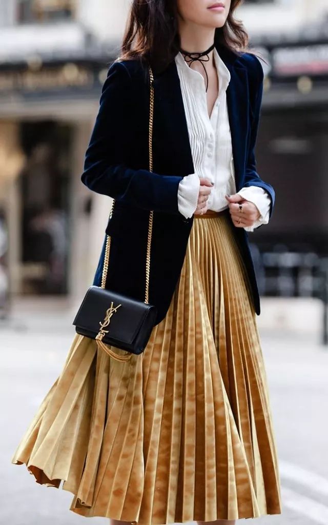 上半身的衬衫与西装外套,与下半身金色裙子的搭配不俗气却大胆,包包