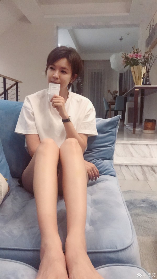 39岁李艾晒美照俏皮似少女 躺沙发看书大长腿太抢镜