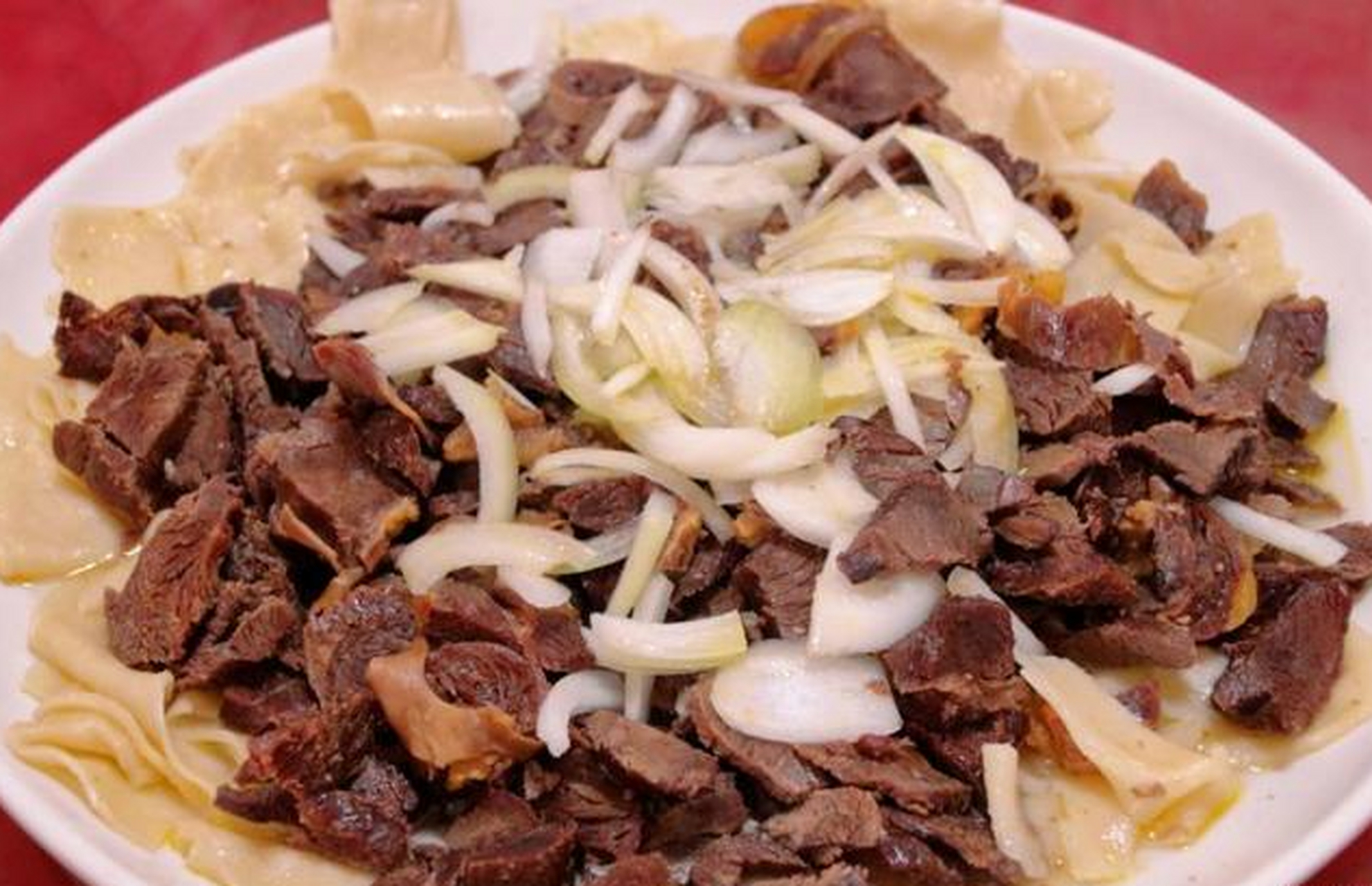 肉汤里煮熟皮带面后,连汤带面浇在熏马肉上.