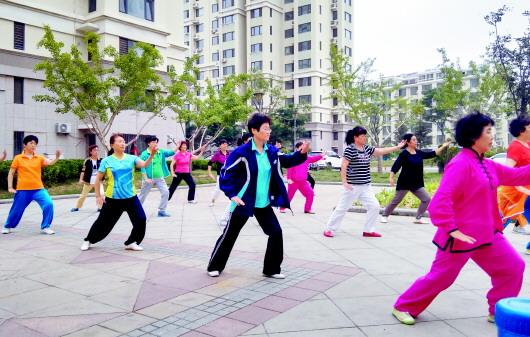 的闲暇时间,辛国英(前排左三)经常参加社区组织的各种文体休闲活动