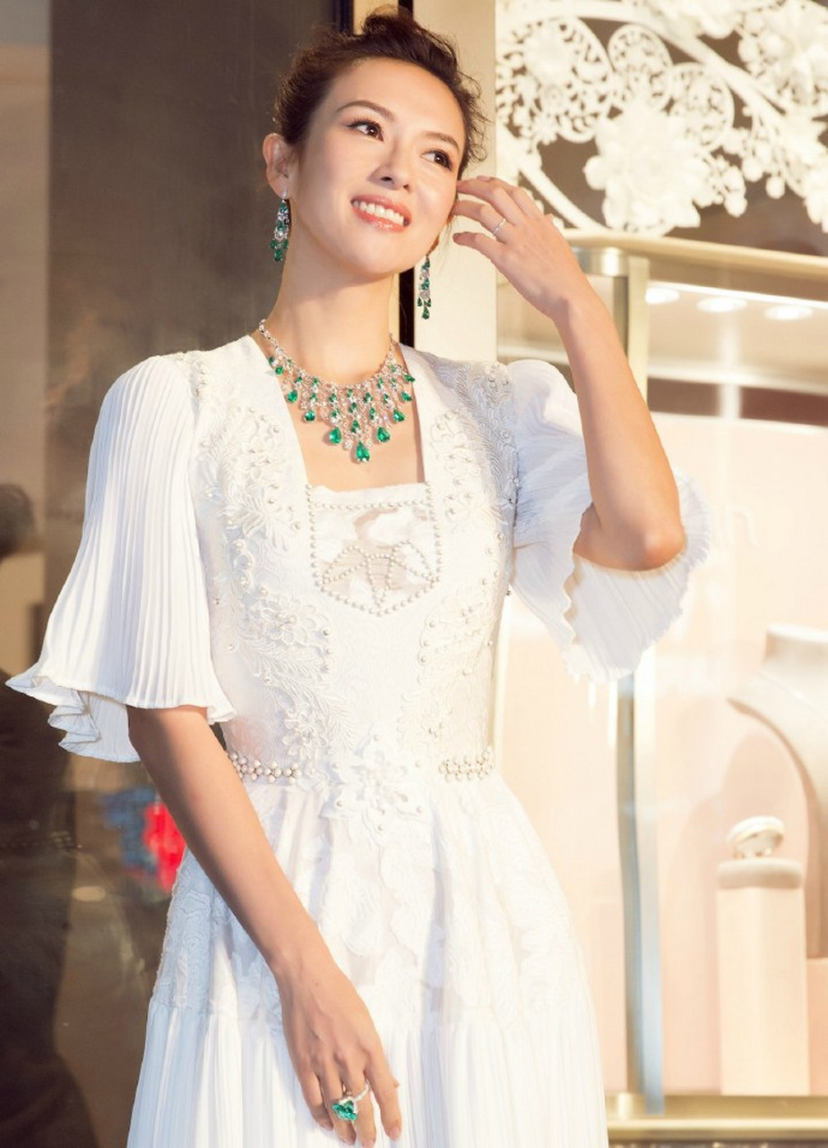 章子怡自带贵气感,身穿白色钉珠百褶连身裙,佩戴绿色珠宝出席活动.
