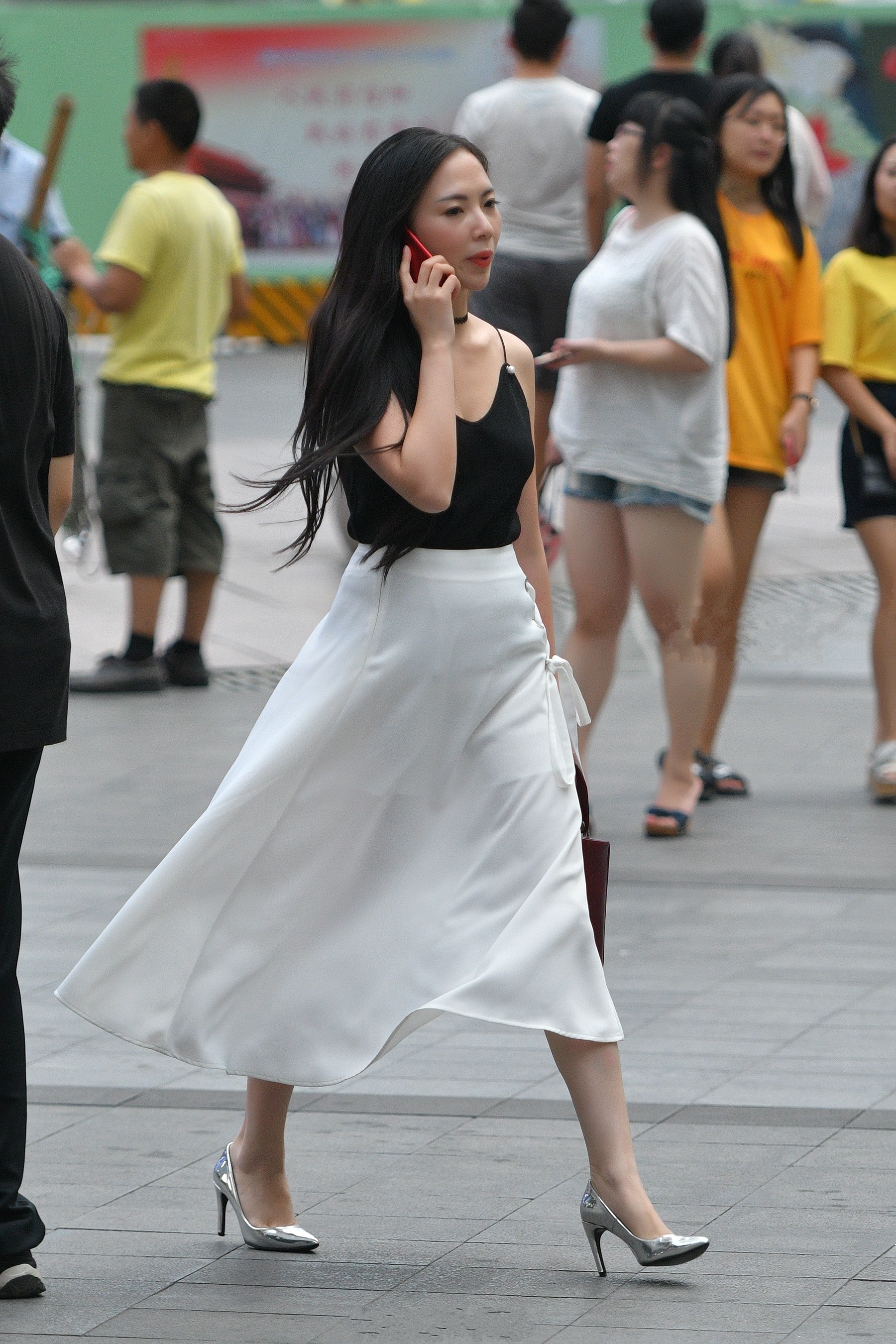 街拍:身穿白色吊带长裙打着太阳伞,十分有气质,身材也很丰满!