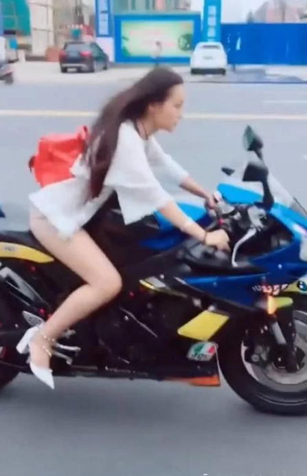 女人一脚踩着摩托车图片