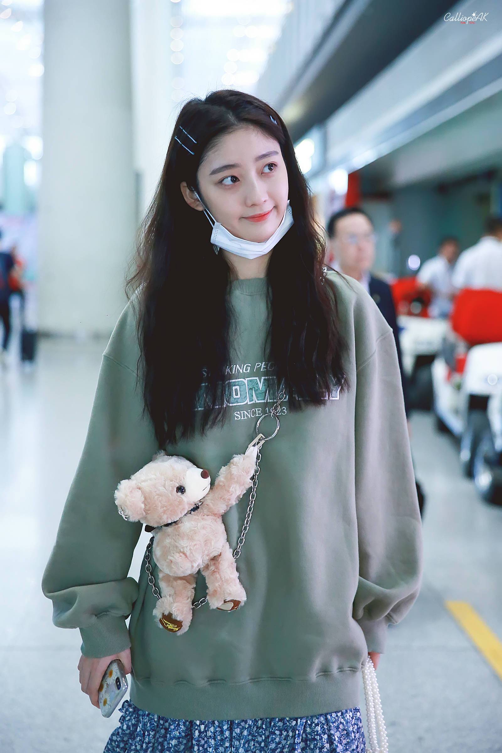 戚砚笛穿军绿色卫衣搭配蓝色碎花裙现身机场,皮肤白皙,面带微笑.