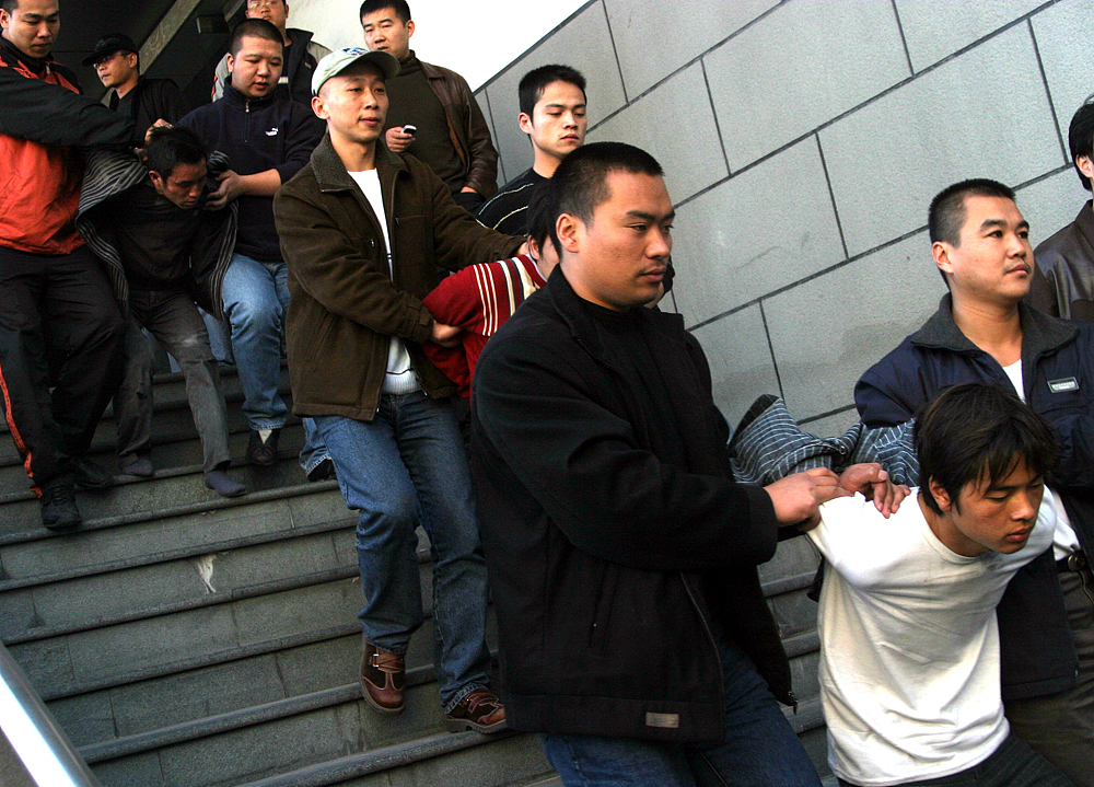 这位男子因为盗窃行为被愤怒的群众捆绑在树上,遭受了众人的唾弃和