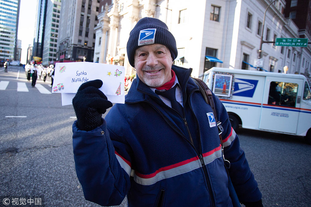美国费城举办感恩节大游行 邮差沿街为圣诞老人收信