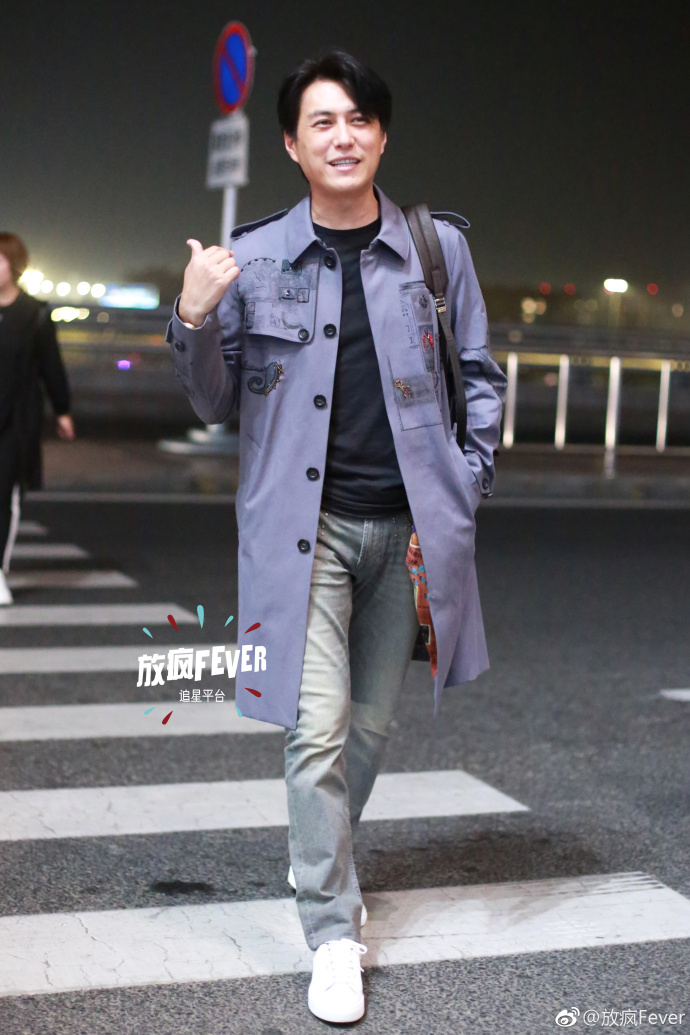 靳东穿灰色风衣搭配蓝色牛仔裤现身机场,笑容灿烂帅气十足
