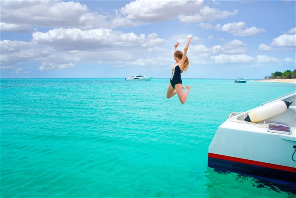 碧绿的海水,一名身穿黑色的泳衣的姑娘正在高兴的跳水游游.