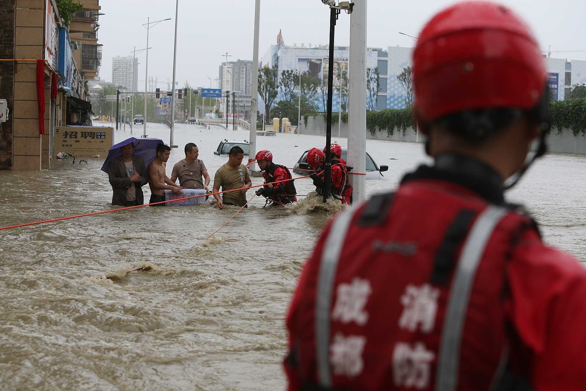 消防员迅速到达现场,冒着持续降雨和湍急的洪水,展开救援.