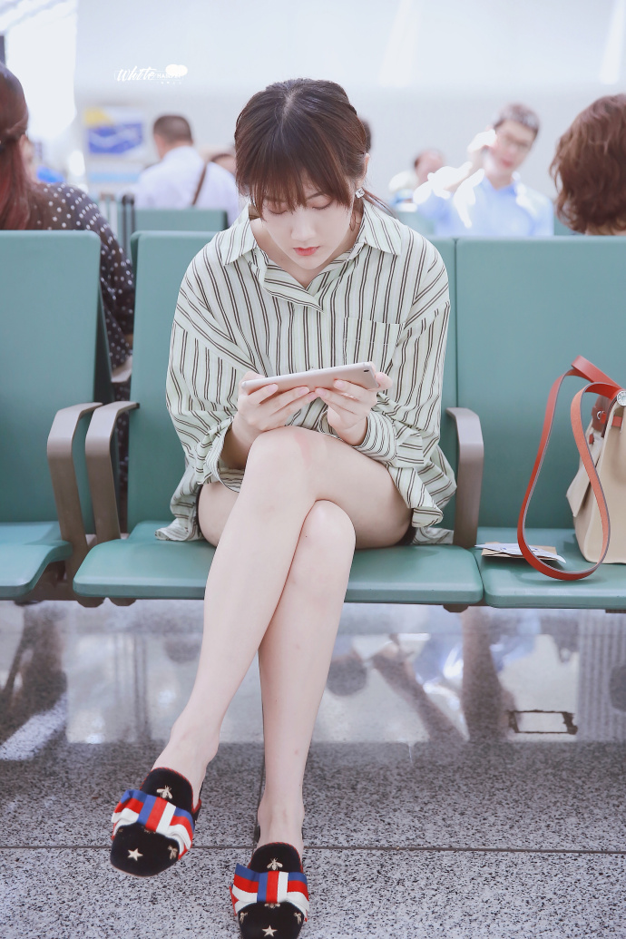 李艺彤穿条纹衬衫搭配黑色牛仔短裤现身机场,腿又白又细十分吸睛