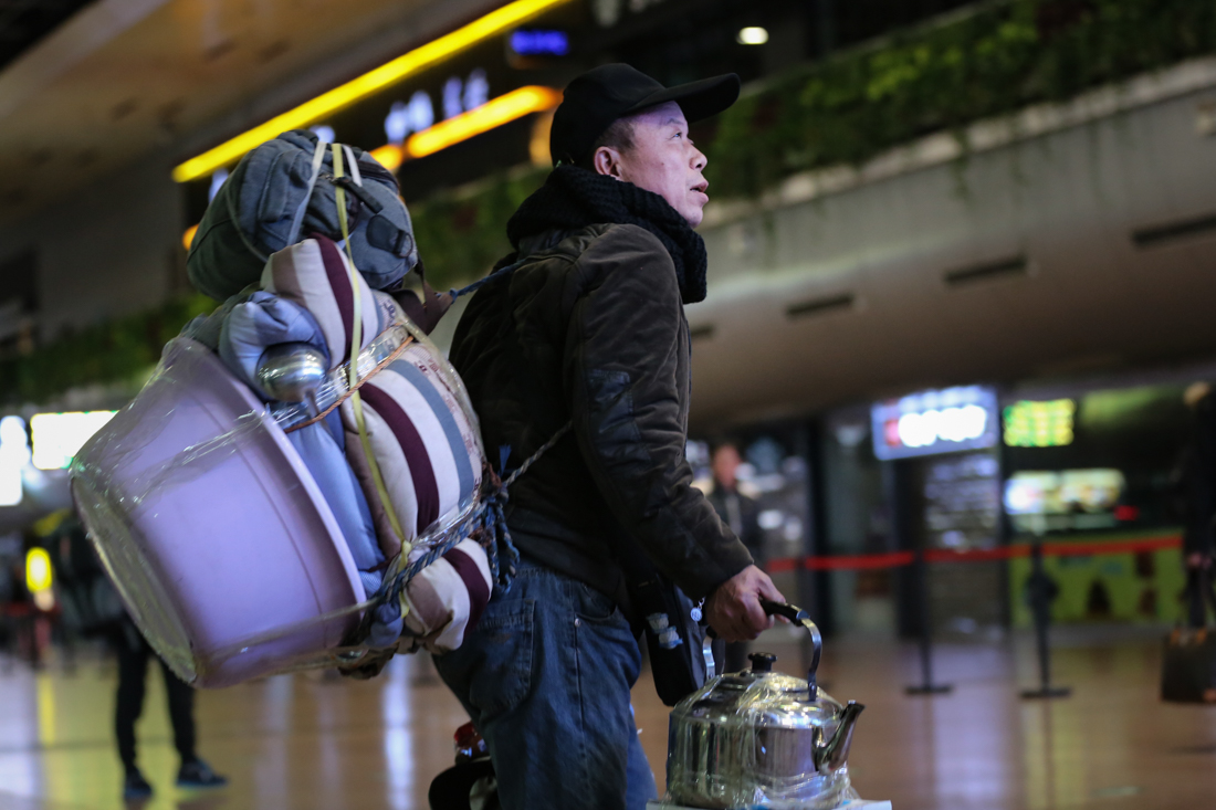 北漂务工者扛包返乡 带2万元回家依然满足