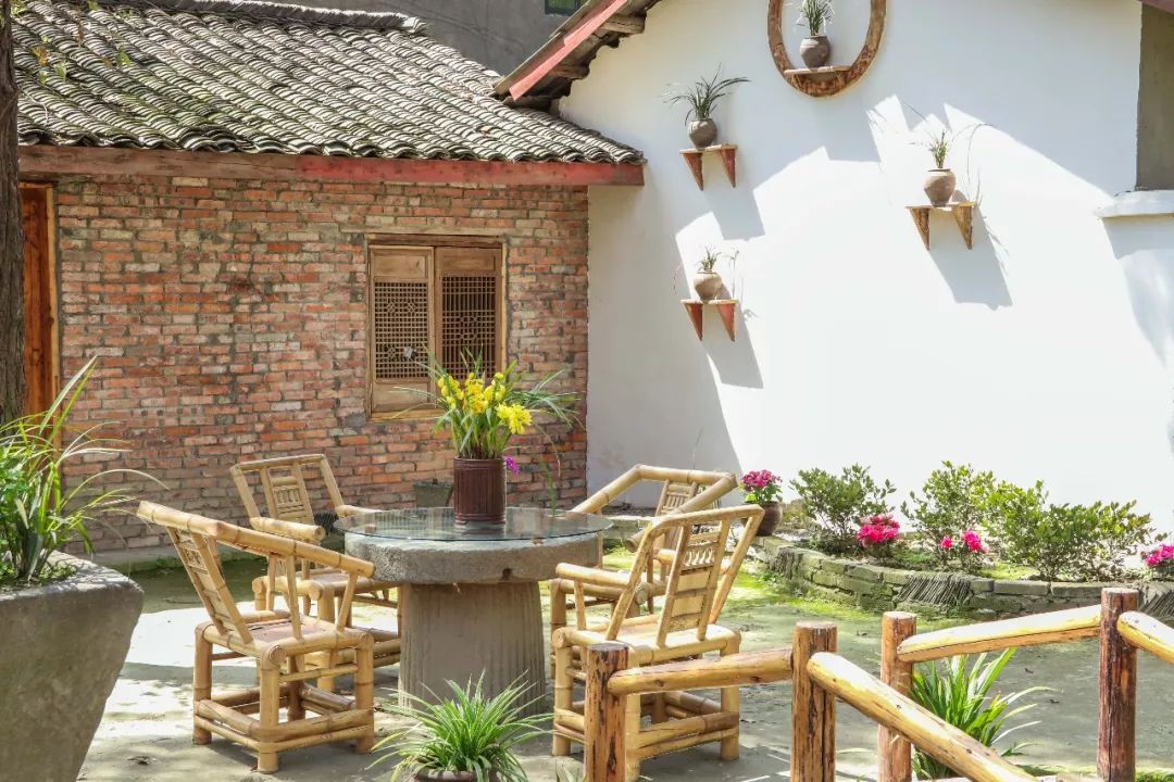 传统的川西小院风格,白墙青瓦,阳光从绿树间透了下来,洒在脸上,温暖