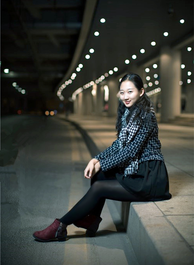 一个依偎在夜晚灯光下的开心美丽女子