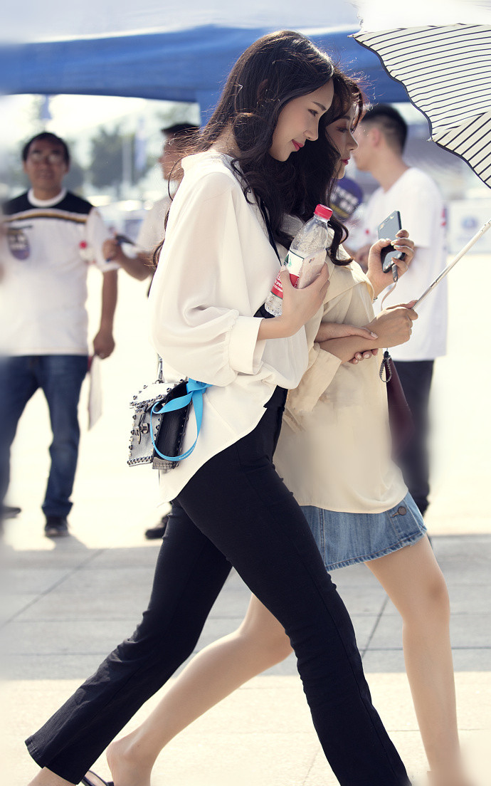 白衣美女低头浅笑,动作十分迷人!