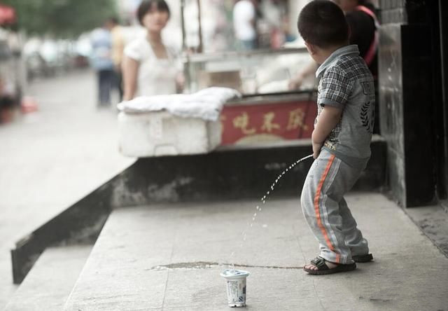 小男孩用瓶子接尿自己图片