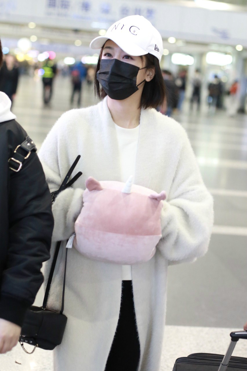 杨紫穿白色毛绒风衣现身机场,戴白色棒球帽和黑色口罩挡不住美