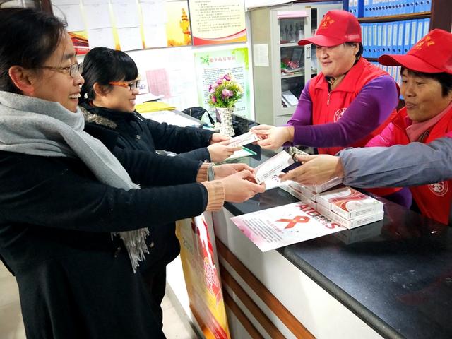 社区党员志愿者正在给居民发放计生用品.柏南二社区 周彦东/供图