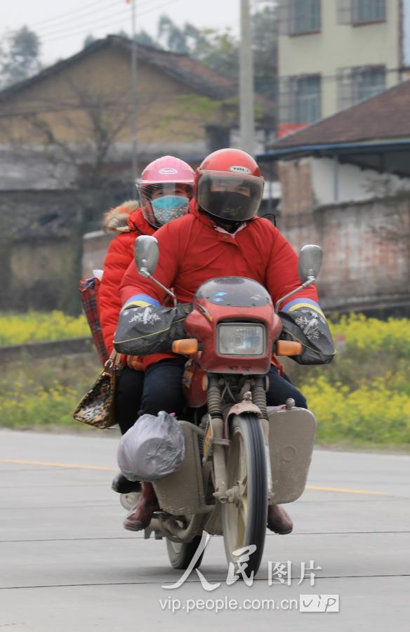 1月22日,返乡人员骑摩托车行走在209国道广西柳州市融安县浮石镇桥头