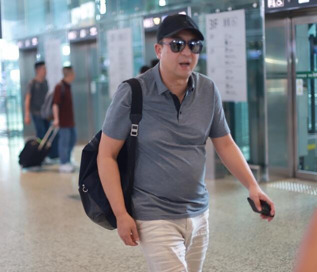 张嘉译脚踩人字拖现身机场,大肚腩格外抢镜,左腿红绳本命年?