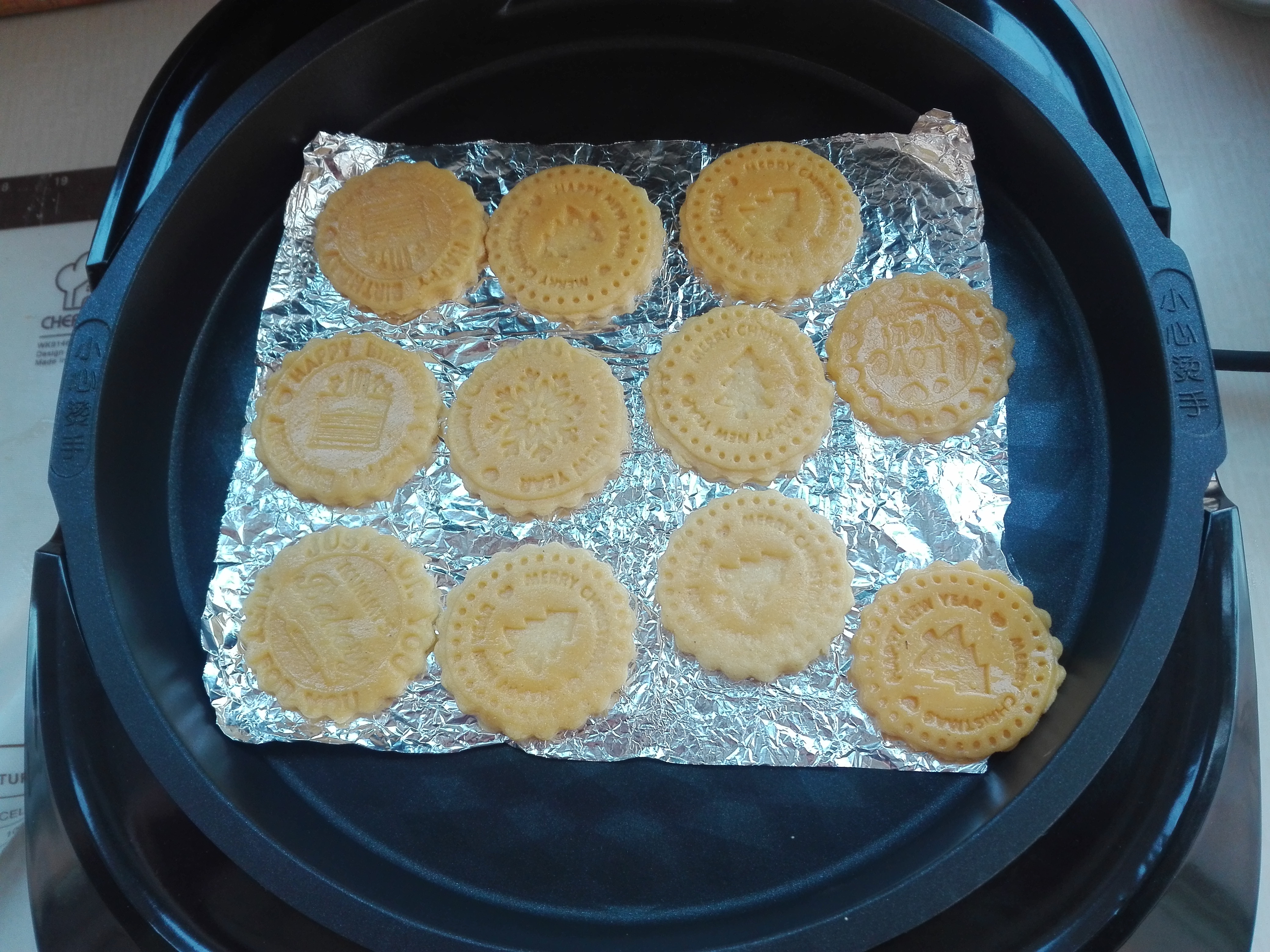 10,电饼铛提前进行预热,放入锡纸,预热好后,分别将做好的饼干胚,依次