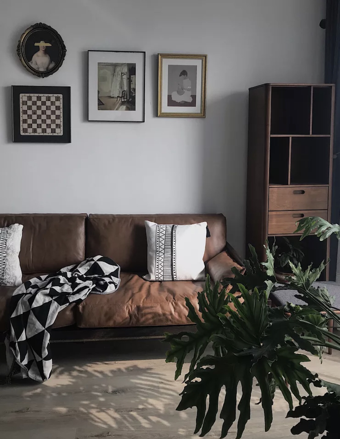 哑光皮质的棕咖沙发配上同色系的边柜,这样稳重的颜色可以给整个空间