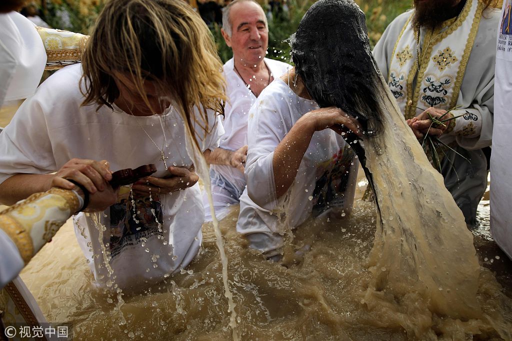 约旦河西岸:基督教朝圣者在泥水中受洗 庆祝主显节