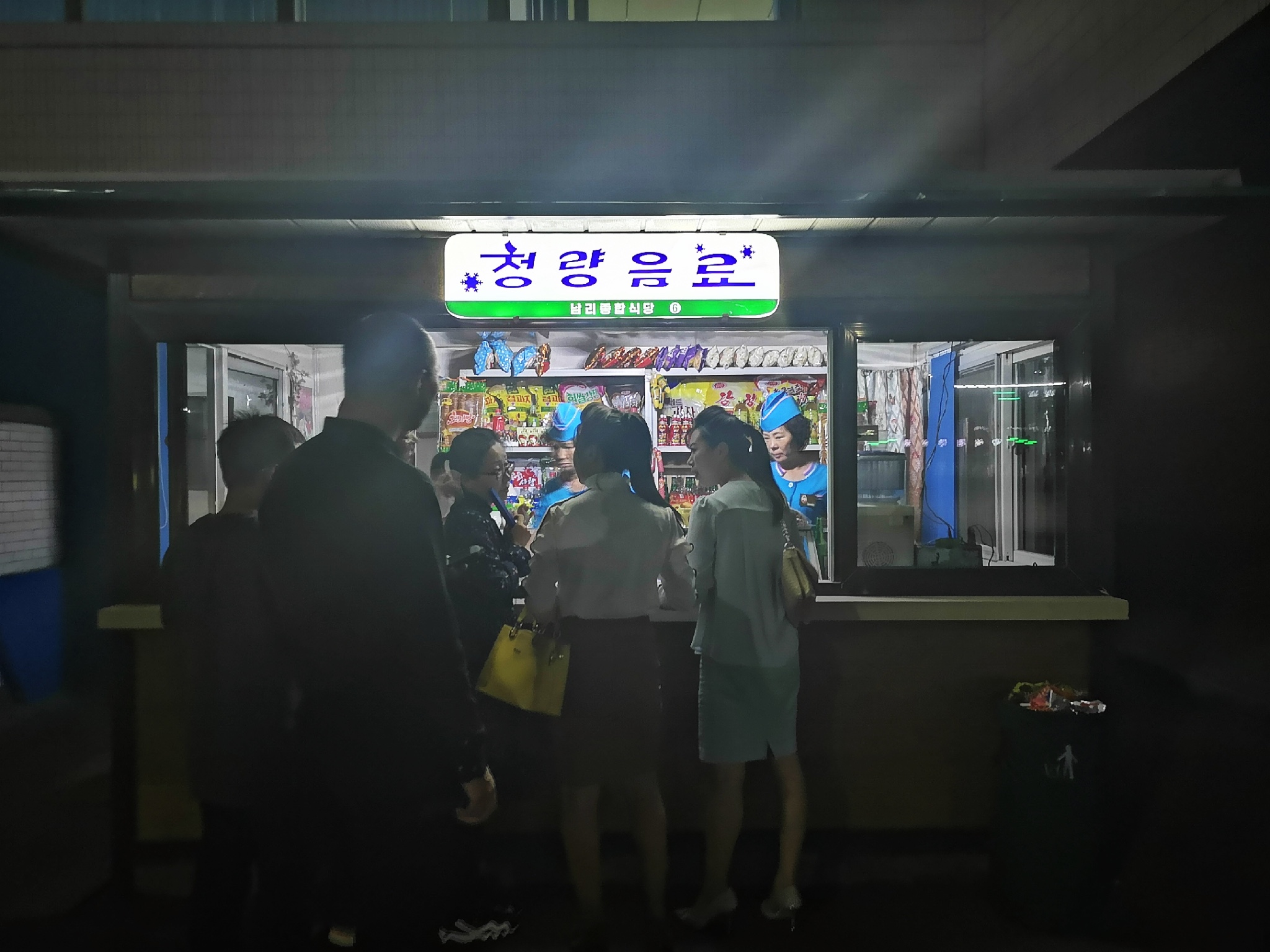 图为夜间正在营业的小卖部,不少下夜晚的上班族在小卖部购物.