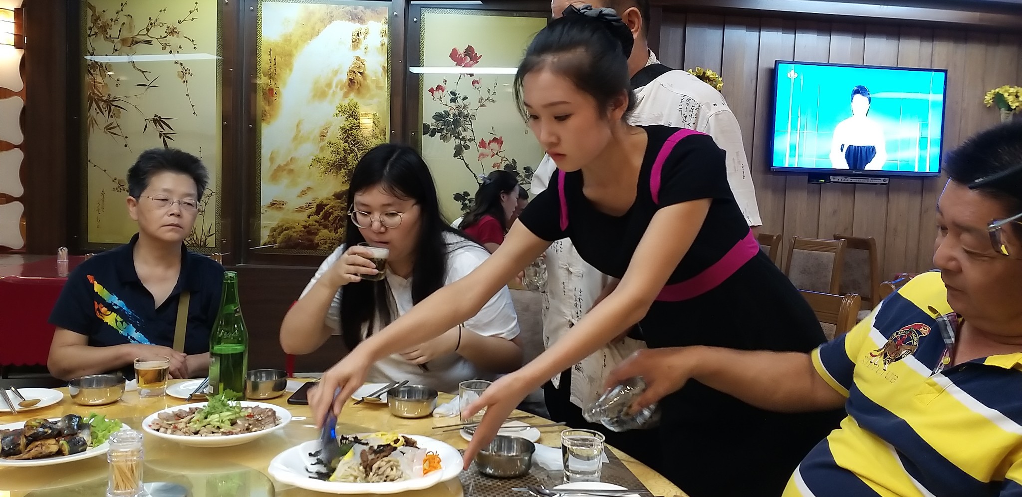 图为朝鲜一家涉外餐馆的女服务员,正在为游客上菜的她长得很漂亮.