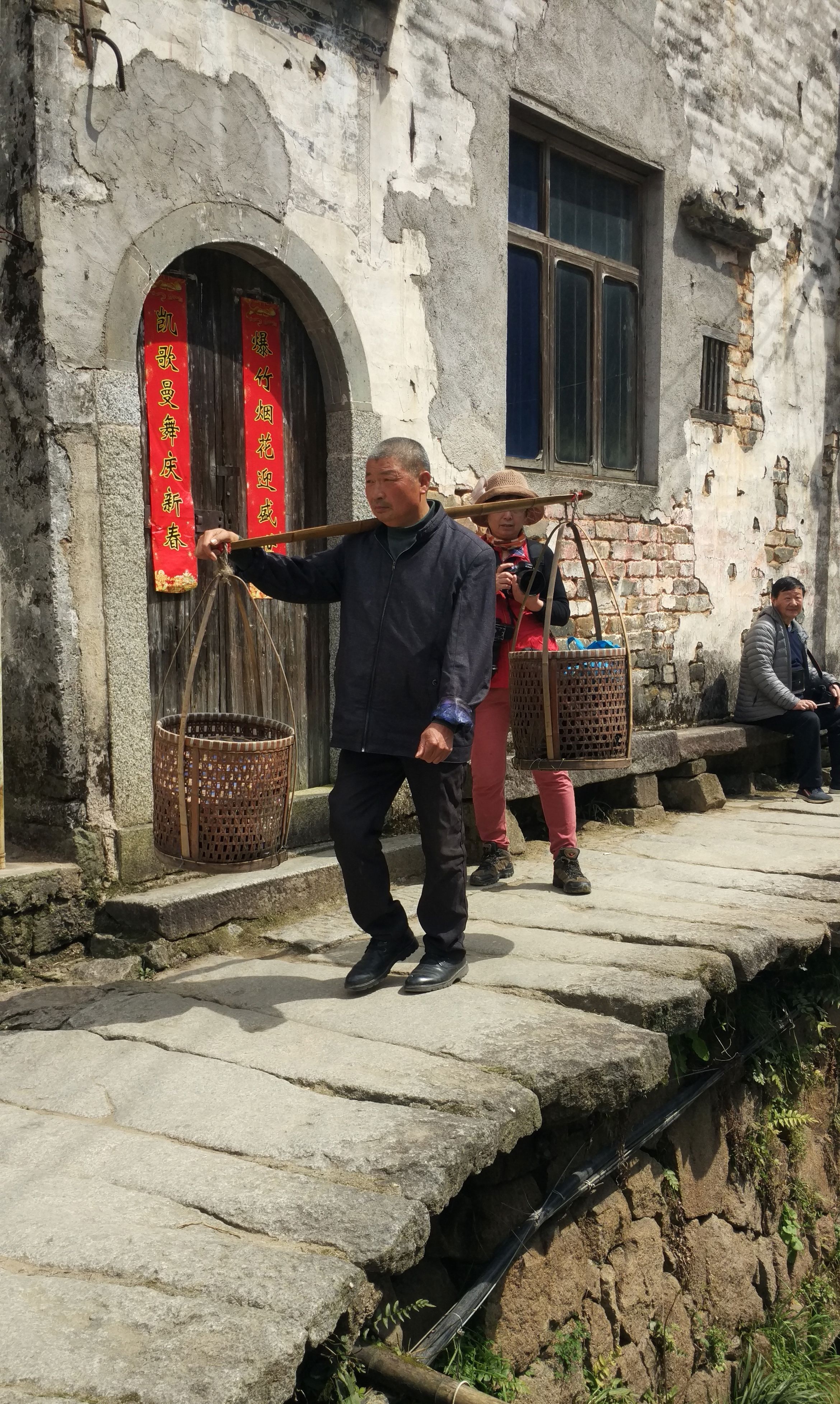 乡民挑着已经发红的竹篓子准备回家吃午饭.