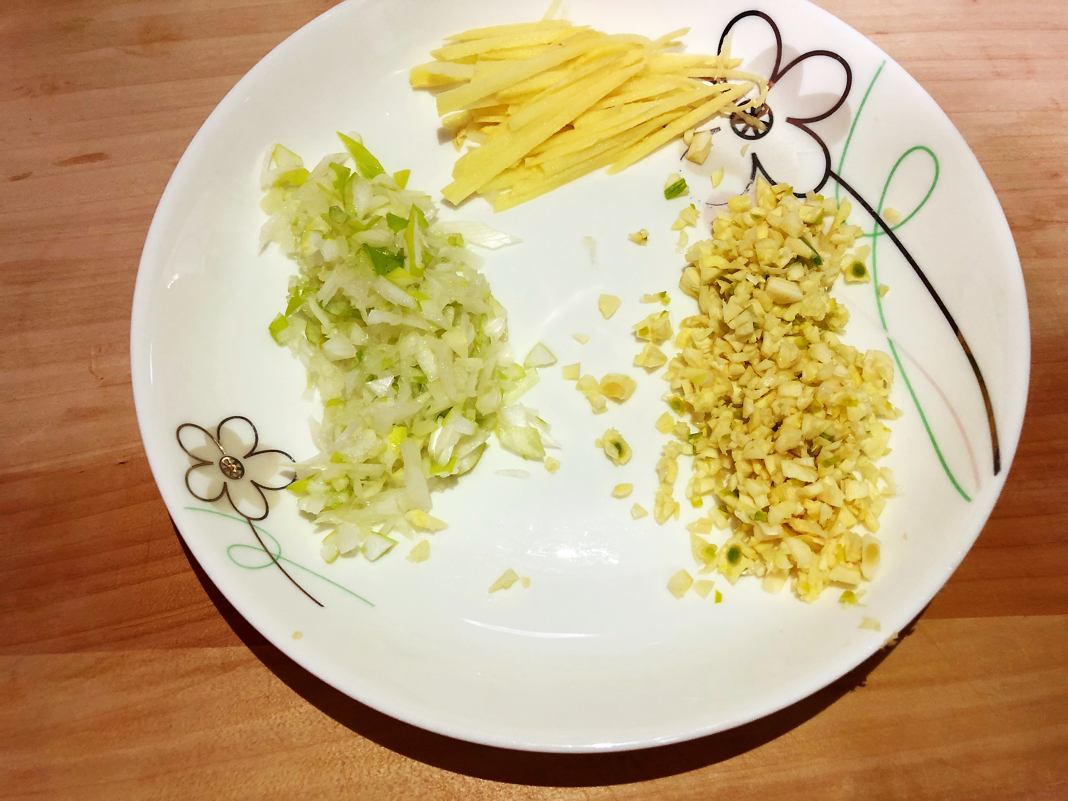 泡排骨的同时我们来准备辅料, 大葱切末,姜切丝,蒜也切末放入盘中备用