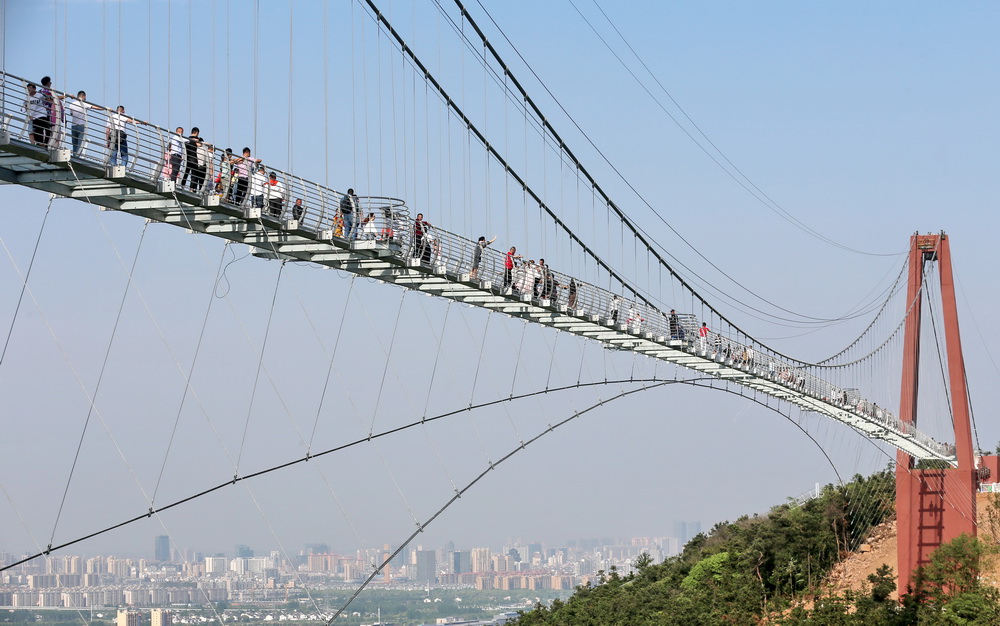 5月4日,游客在江苏省江阴市华西世界探险公园内的凌空玻璃桥上游览