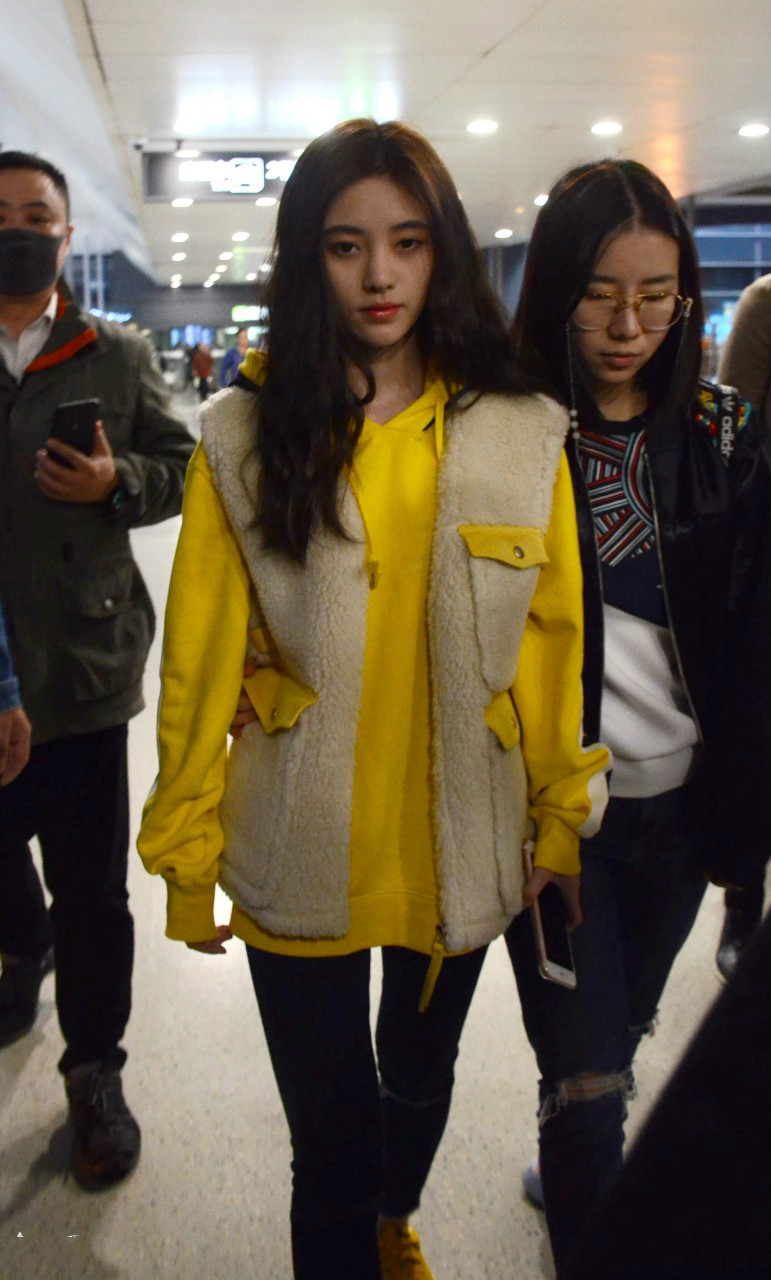 鞠婧祎穿毛绒马甲内搭黄色卫衣现身机场皮肤白皙