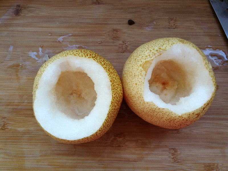 将两个梨的梨核用勺子挖掉,底部千万不要挖穿.否则汁儿会流到烤盘里.