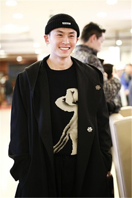 张哲瀚穿长款风衣亮相机场,对镜甜笑暖化人心