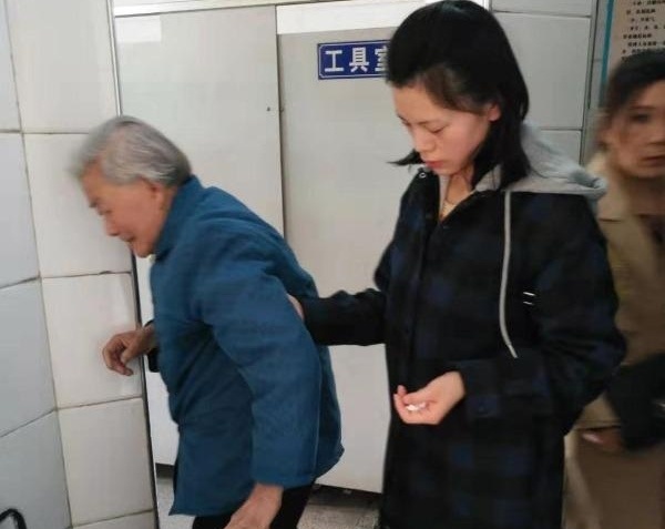 女孩扶89歲輪椅老太上廁所,老人兒子:我會將她的照片一直保存