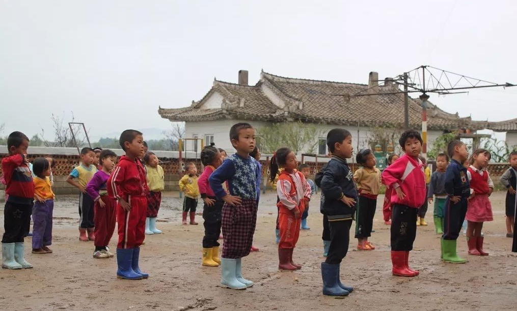 图为朝鲜一家幼儿园的孩子们,正在操场上做操,孩子们的的穿着让人觉得