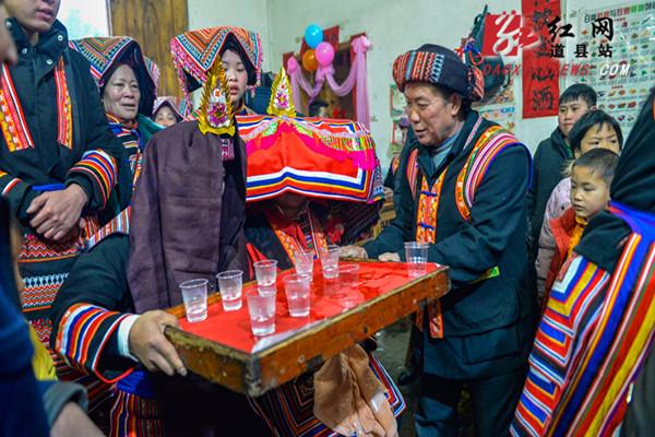 鞭炮响起,鼓乐师吹《水落音》词牌,新郎新娘喝交杯酒,一对新人在密集