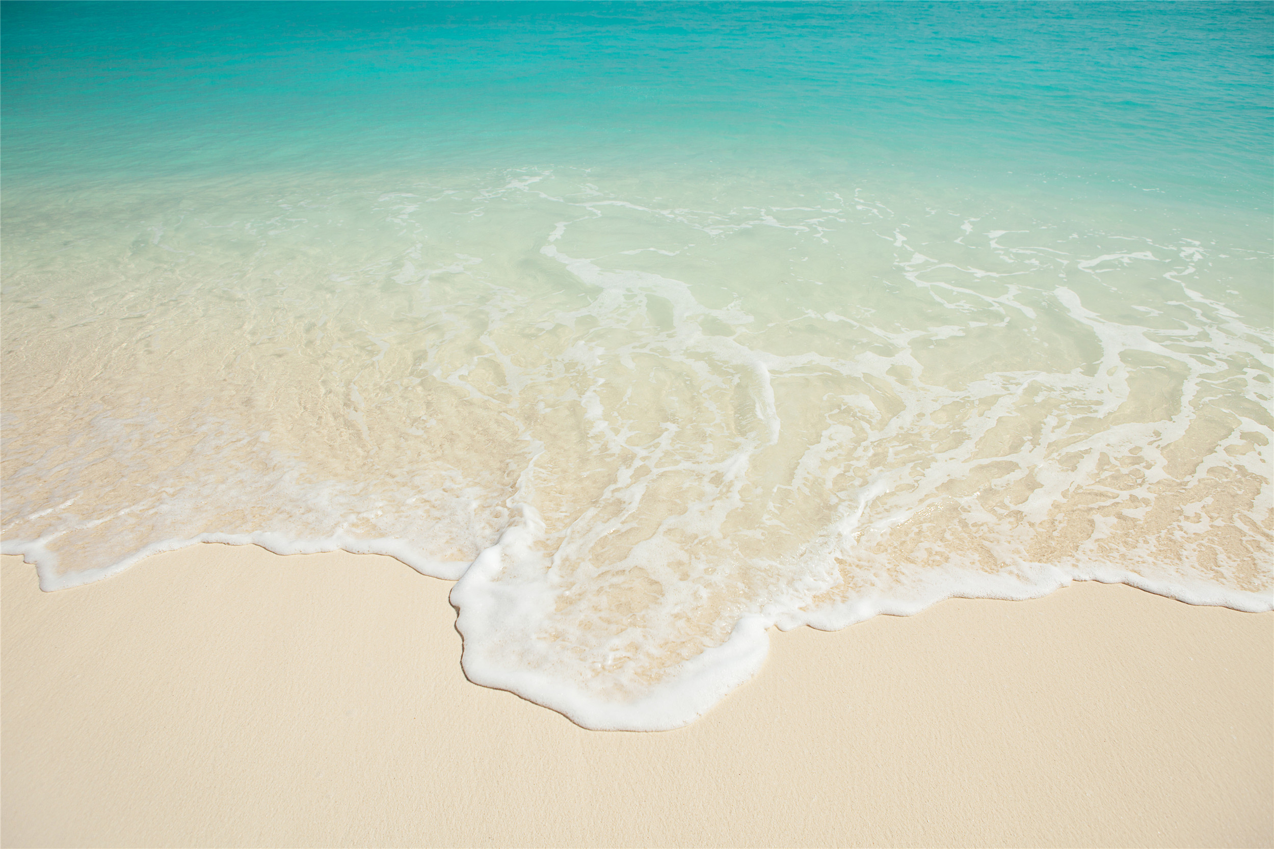 海水涌上沙滩:米白色的沙滩,涌上来的是白色的水花,蓝绿色的海水是