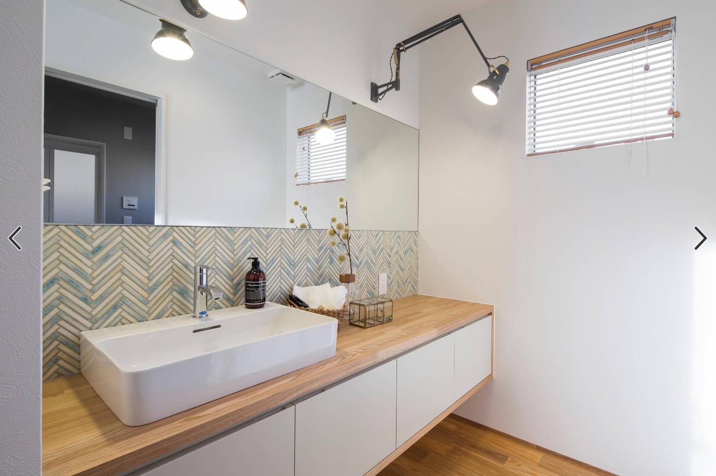 卫生间设计的风格简约大气,以木色和白色为主色调,墙面镶嵌了整面镜子