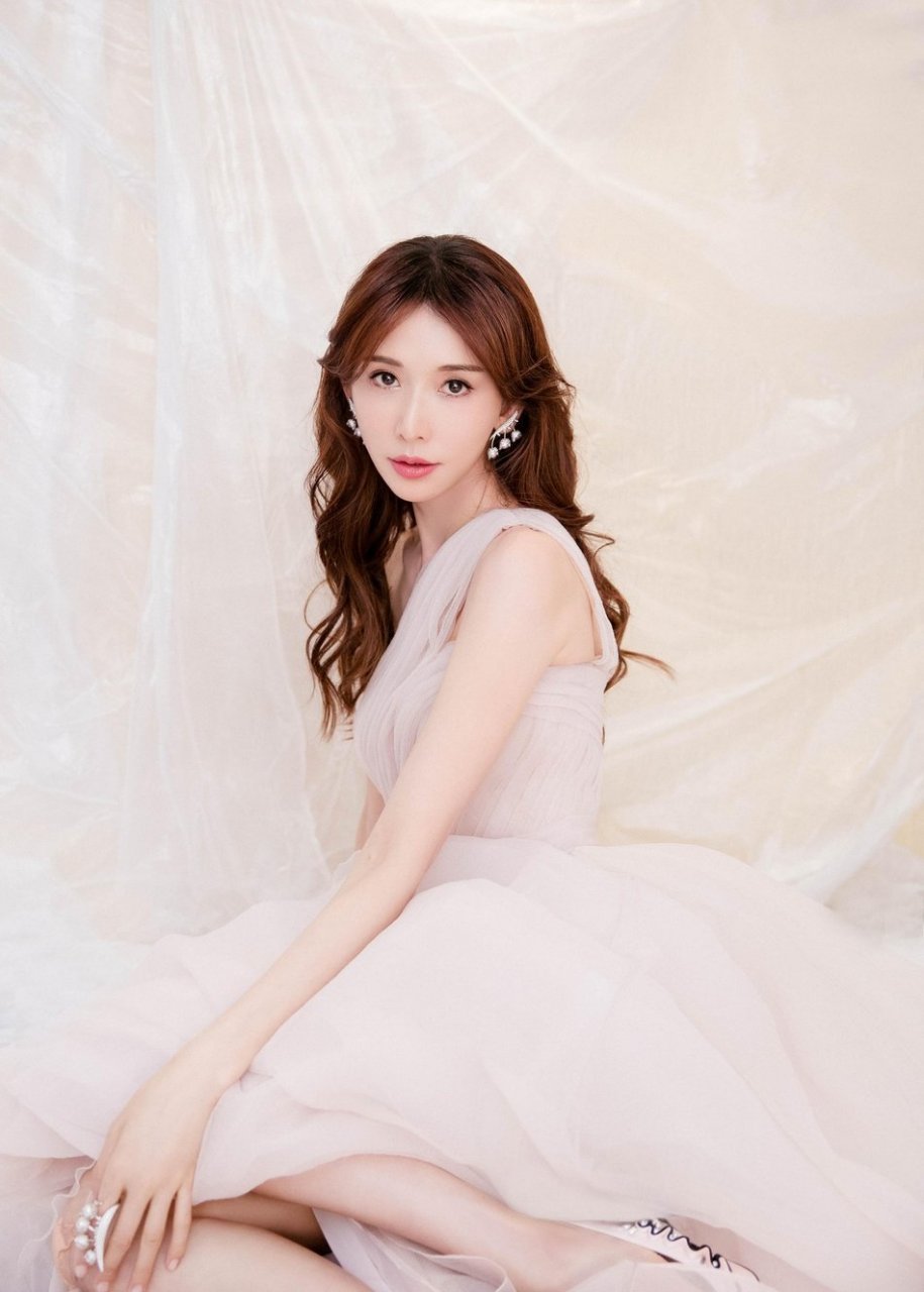 林志玲身穿粉色斜肩柔纱长裙,设计感的风铃花耳环夺目吸睛,清新演绎