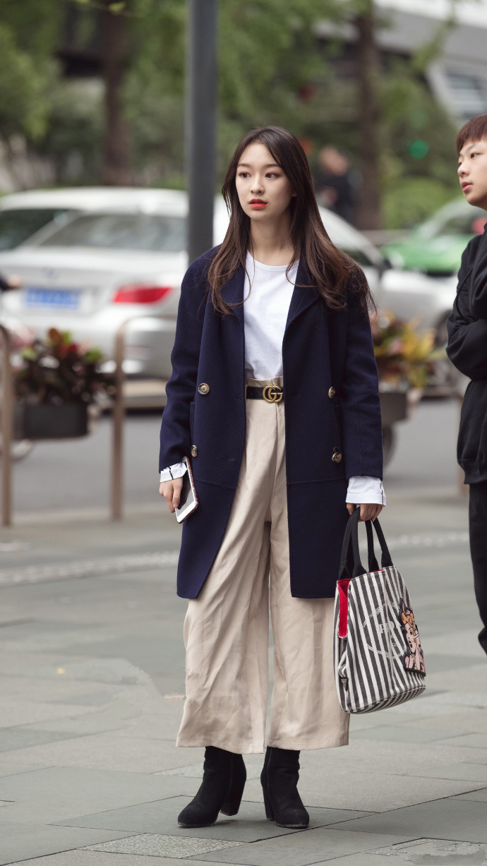 淑女范儿的搭配,一袭白色过膝长裙,搭配蝴蝶结的小白鞋,这位街头美女