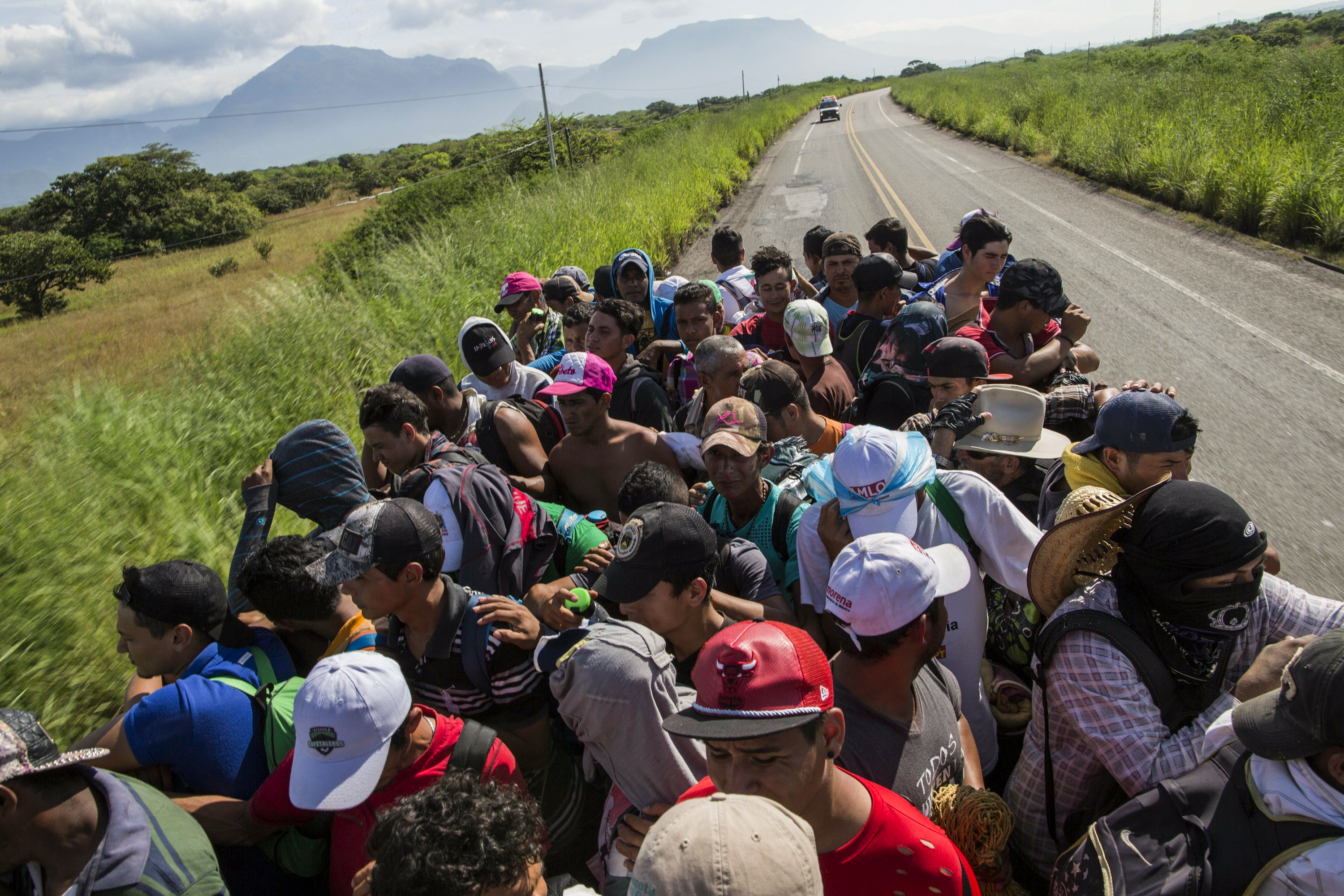 两名中美洲移民即将到达河对面的岸边,兴奋地挥手庆祝.
