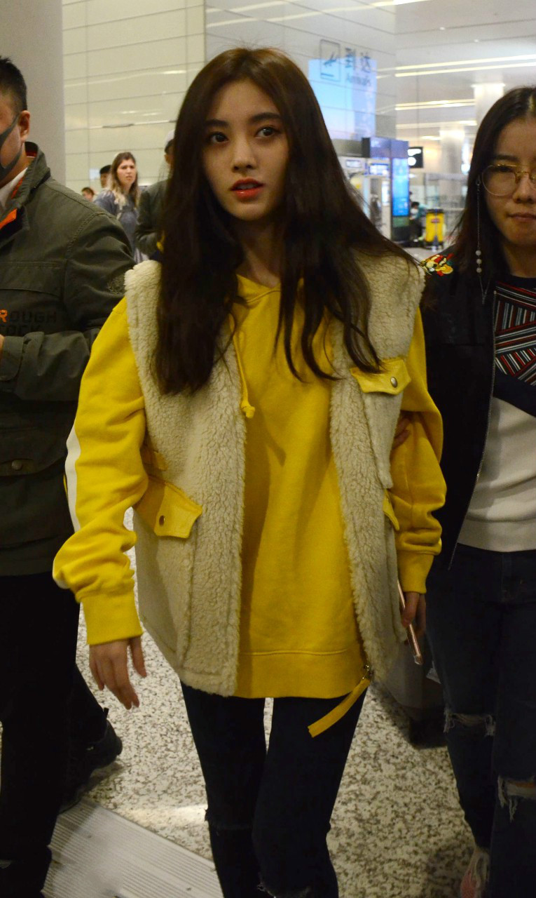 鞠婧祎穿毛绒马甲内搭黄色卫衣现身机场皮肤白皙