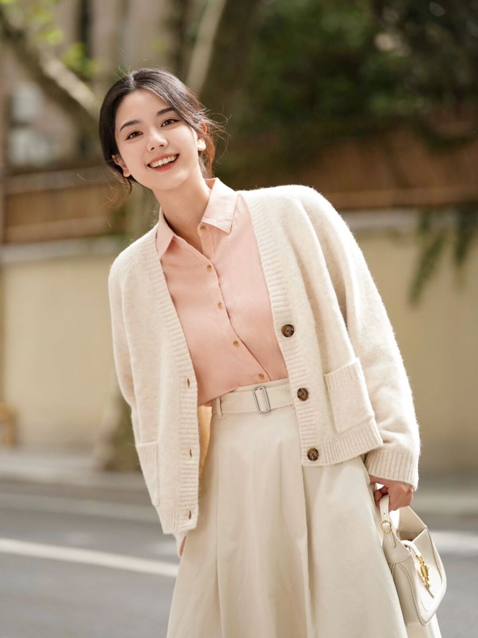 淡粉色衬衫配上白色伞裙,外套一件蓬松轻盈的乳白色舒芙蕾针织开衫 一