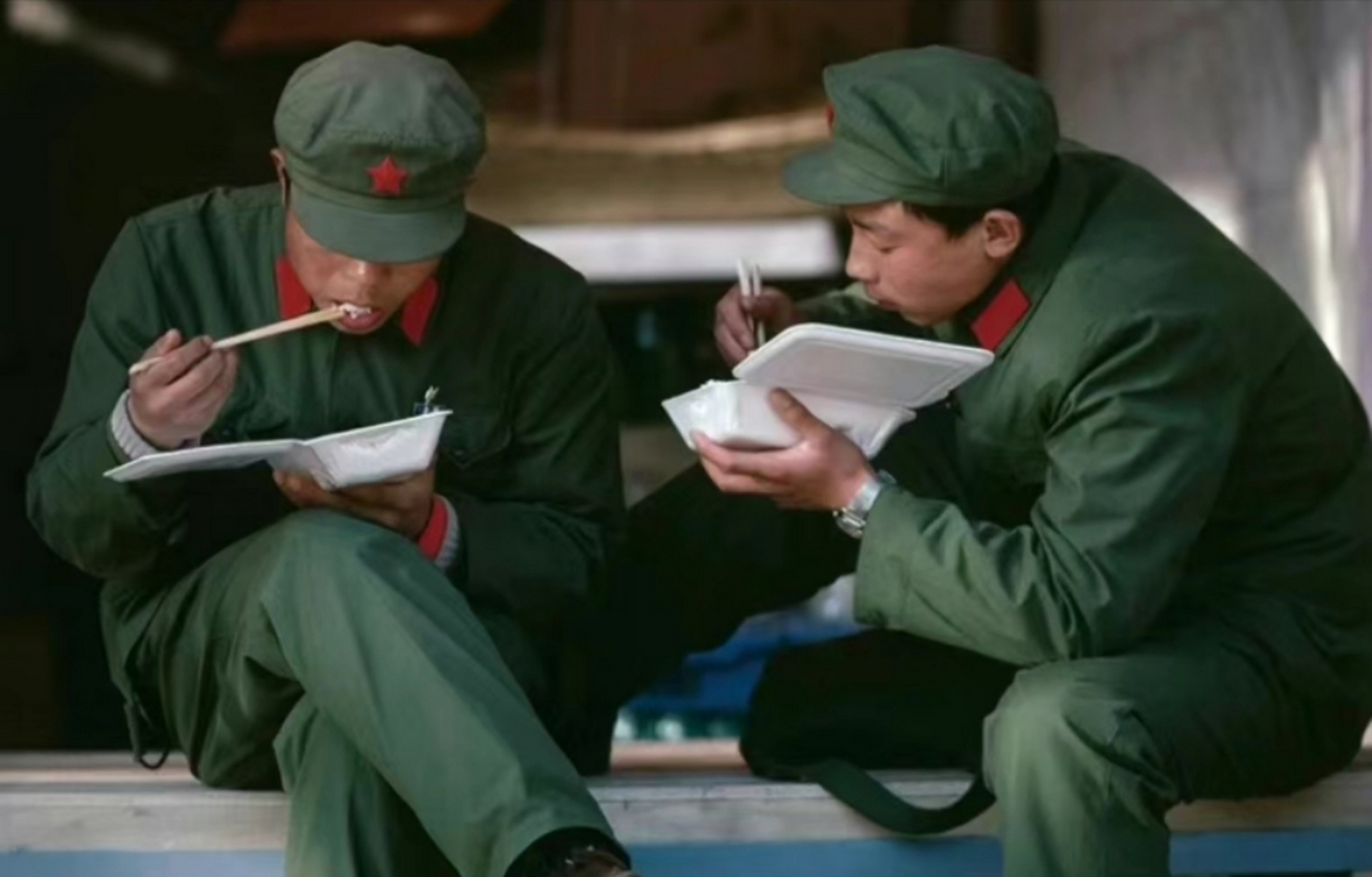 1985年,北京街头,两名身穿六五式军装的解放军战士,正在吃盒饭!
