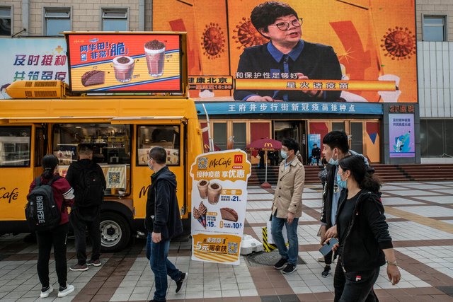在北京一家新冠疫苗接种中心外,麦当劳的冰淇淋车为接种者推出“买一赠一”的促销活动。