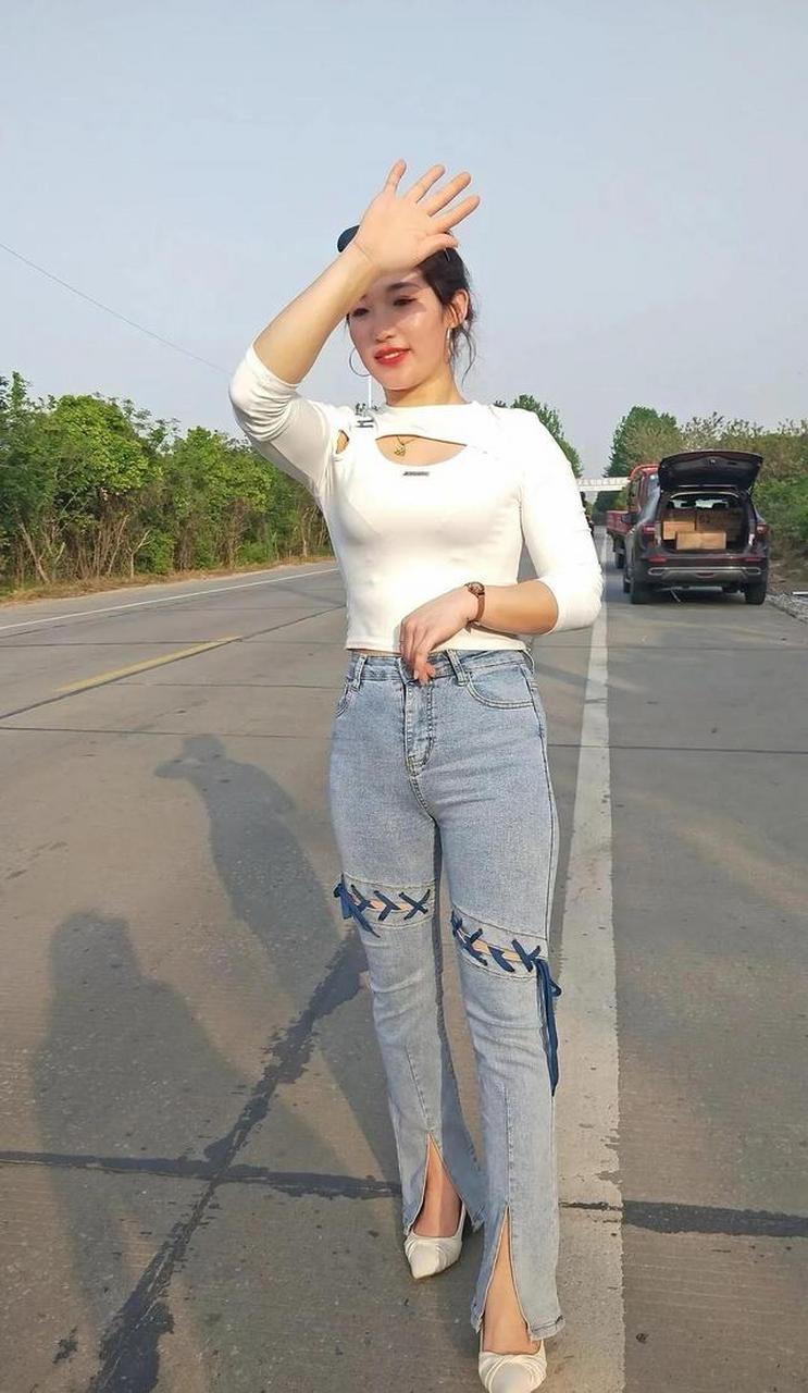 白色低胸上衣另类牛仔裤搭配白色高跟鞋,凸显成熟好身材!